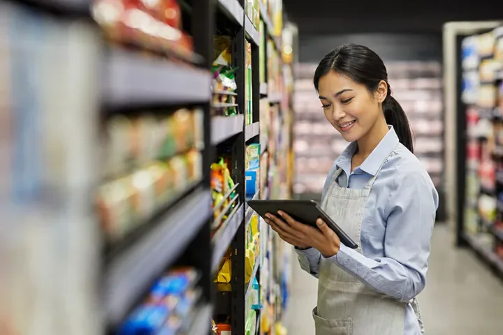 Retail worker reviewing shelf stock with a tablet