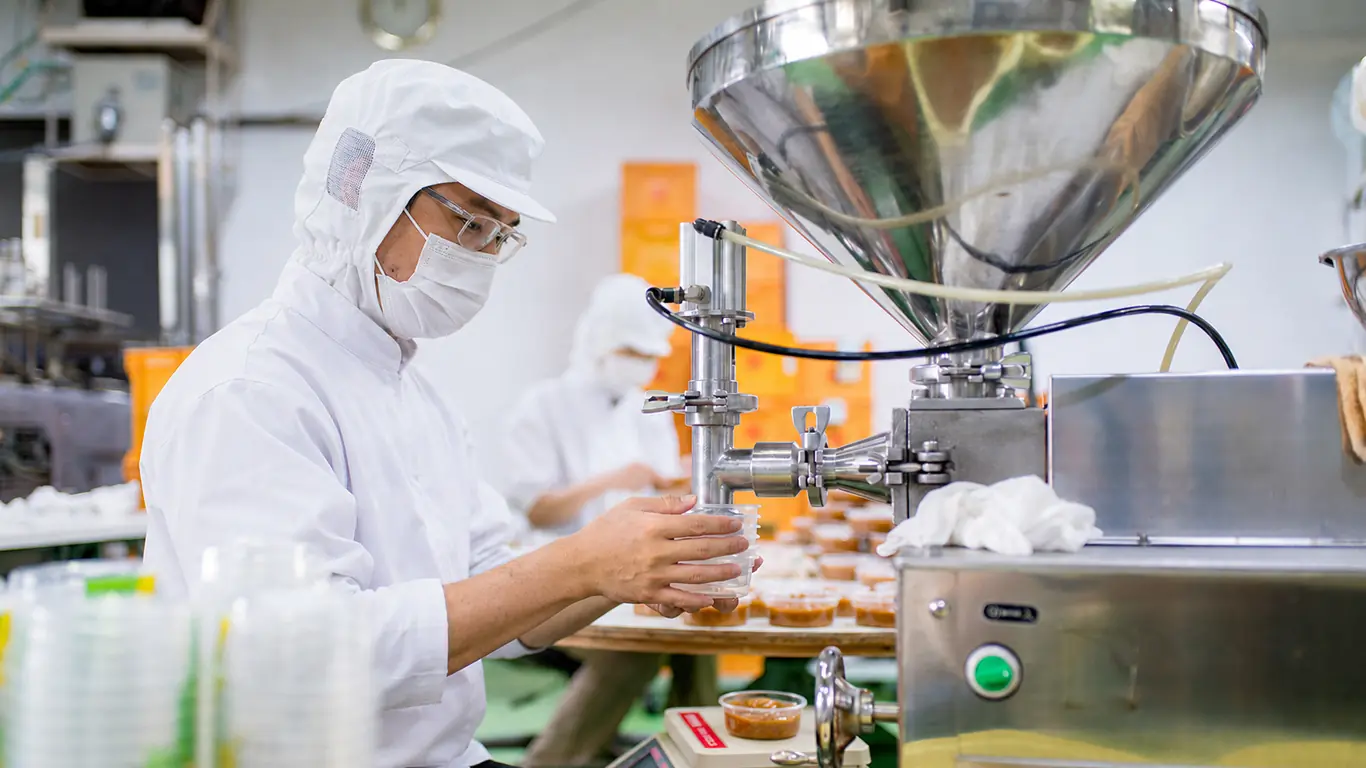 Food production worker operating formulation equipment