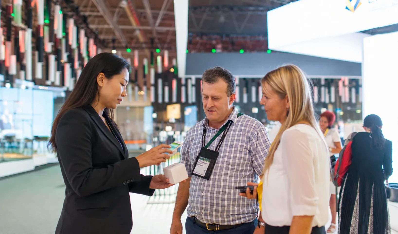 Trade show representative demonstrating a product to buyers